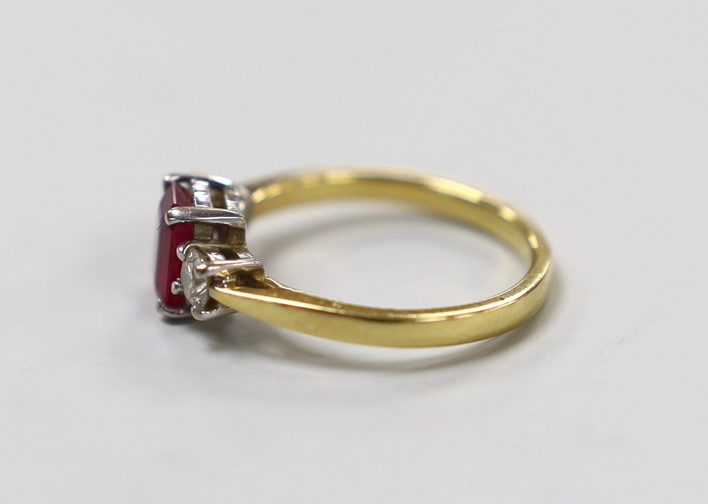 A modern 18ct gold, ruby and diamond set three stone ring, size M/N, gross weight 3.8 grams.